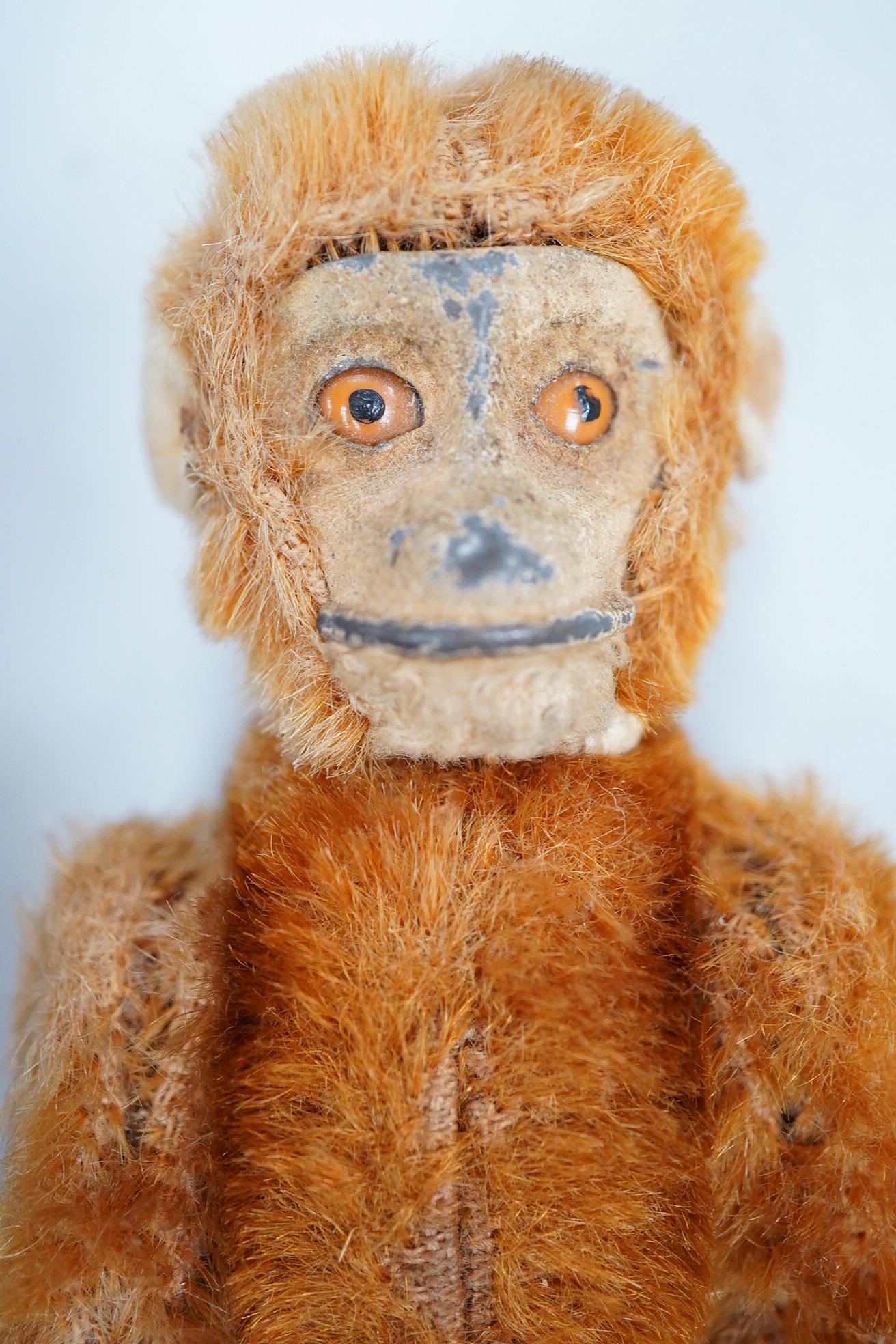 A German Schuco scent bottle monkey, with mohair body containing a glass bottle, together with a white metal Japanese style lid box decorated with a floral landscape and bird of prey to the lid